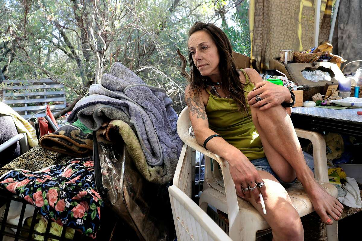 Billie Jo leans back at her homeless encampment near unincorporated Cameron Park in El Dorado County, which has seen its homeless population jump 122 percent since 2015.