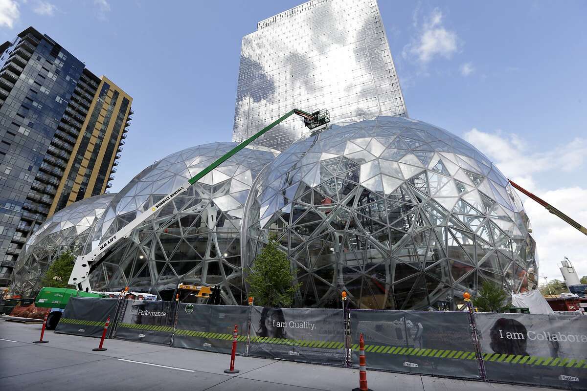 FILE - In this April 27, 2017 file photo, construction continues on three large, glass-covered domes as part of an expansion of the Amazon.com campus in downtown Seattle. Amazon said Thursday, Sept. 7, that it will spend more than $5 billion to build another headquarters in North America to house as many as 50,000 employees. It plans to stay in its sprawling Seattle headquarters and the new space will be "a full equal" of its current home, said founder and CEO Jeff Bezos. (AP Photo/Elaine Thompson)