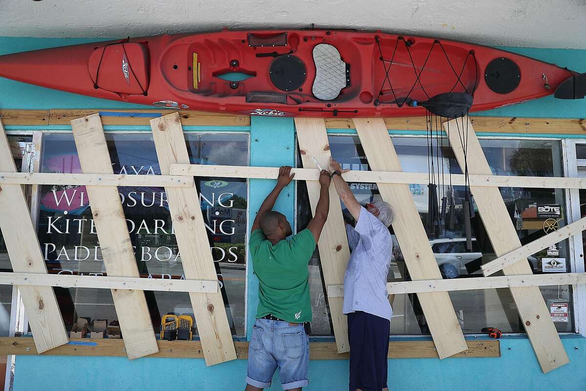 *** BESTPIX *** MIAMI, FL - SEPTEMBER 07: 07:Jim DeSilva and Milton Ibanez (L-R) put window protection on their business, Sandy Point, as they prepare for Hurricane Irma on September 7, 2017 in Miami, Florida. It's still too early to know where the direct impact of the hurricane will take place but the state of Florida is in the area of possible landfall. (Photo by Joe Raedle/Getty Images)