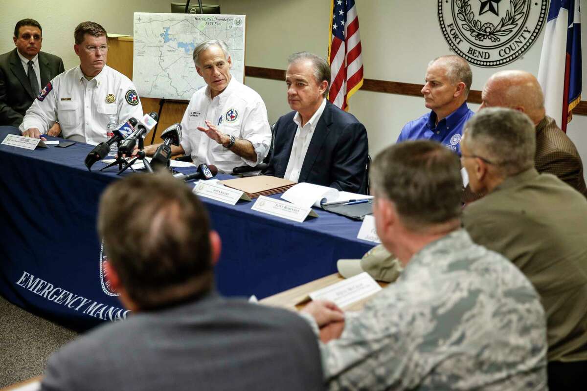 Gov. Greg Abbott, with Texas A&M Chancellor John Sharp (in jacket), outlines the Rebuild Texas efforts Thursday at a meeting with Fort Bend County mayors. ﻿
