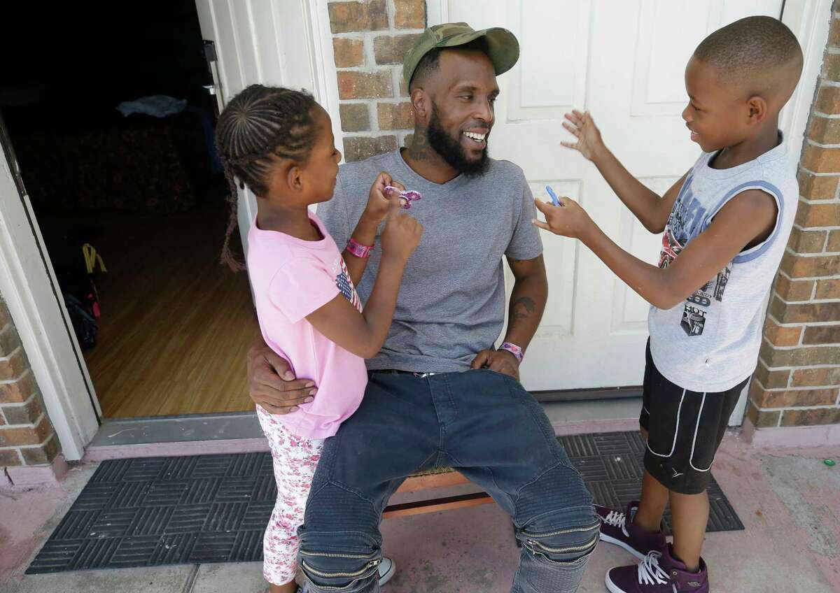 Natalie Spears, 8, and her brother Christopher Spears, 9, show Brandon Polson their fidget spinners while in the Humble area motel Thursday, Sept. 7, 2017, where the family is staying after escaping their flooded apartment in the aftermath of Hurricane Harvey. The family has a hotel voucher from FEMA for temporary lodging through Sept. 25 and they're not sure where they'll go next. They recieved donated shoe while in a shelter.