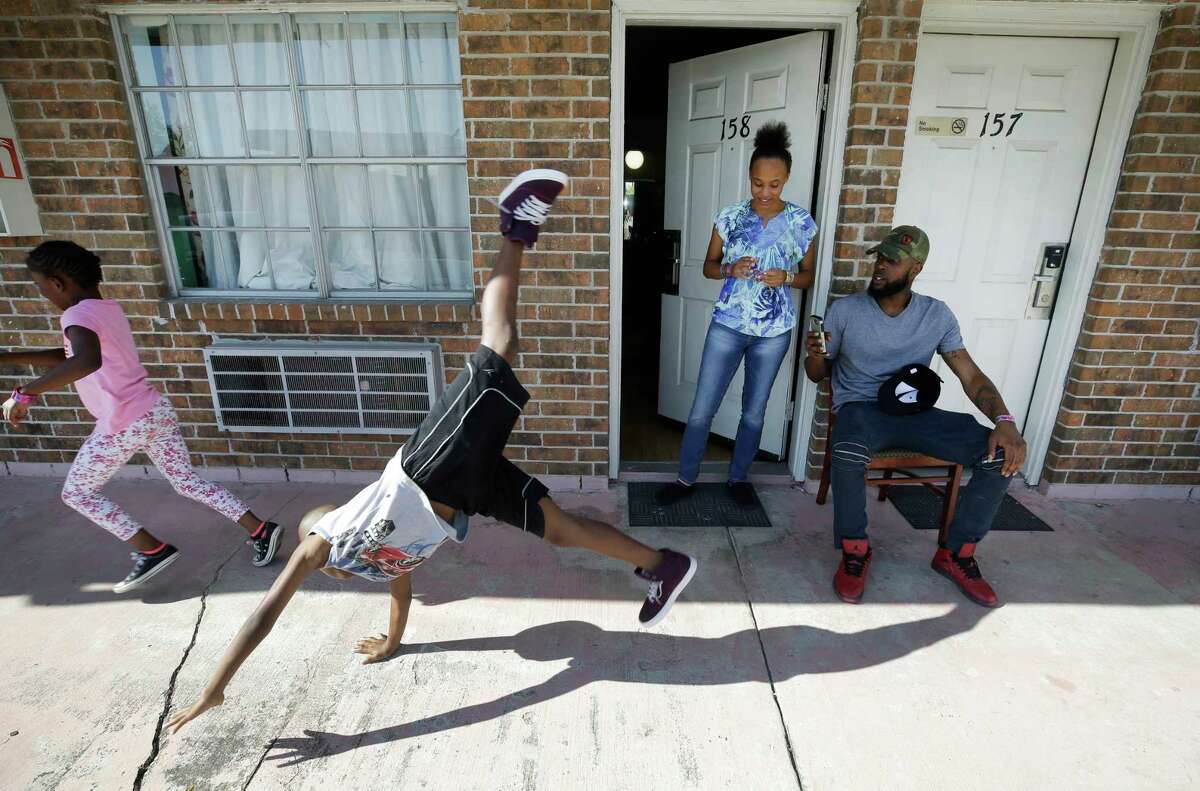 Natalie Spears, 8, and her brother, Christopher Spears, 9, play as their mother, D'?•Ona Spears, watches and Brandon Polson takes a video outside the Humble-area motel Thursday, Sept. 7, 2017, where the family stayed after escaping their flooded apartment in the aftermath of Hurricane Harvey. In total, FEMA funded hotel rooms for 54,640 families during the 308 days the program, which came to end this month, was active.