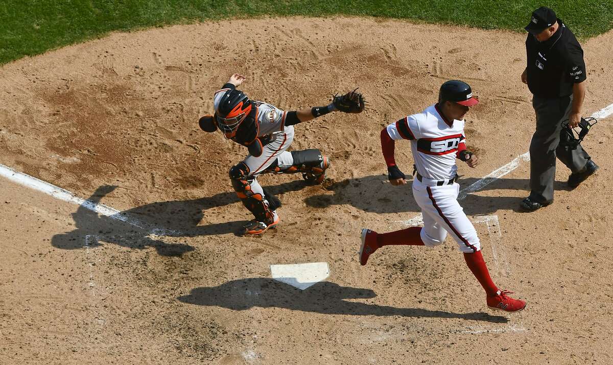 Chicago White Sox's Avisail Garcia, center, scores past San Francisco Giants catcher Buster Posey, left, as home plate umpire Eric Cooper looks on during the fifth inning of a baseball game in Chicago, Sunday, Sept. 10, 2017. (AP Photo/Matt Marton)