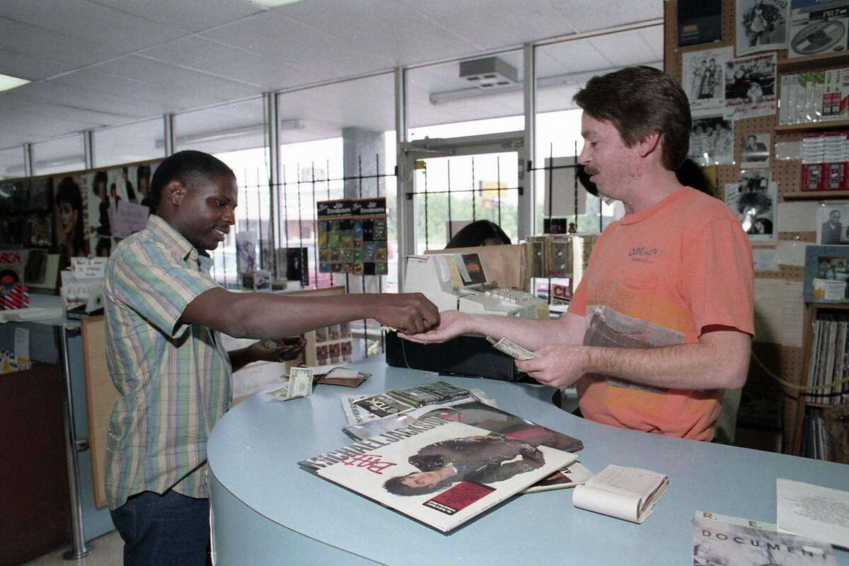 Daryl Moore buys a copy of Michael Jackson's newest album, 'Bad,' from Greg Zachary at Soundwaves, 9150 S. Main, Aug. 31, 1987.