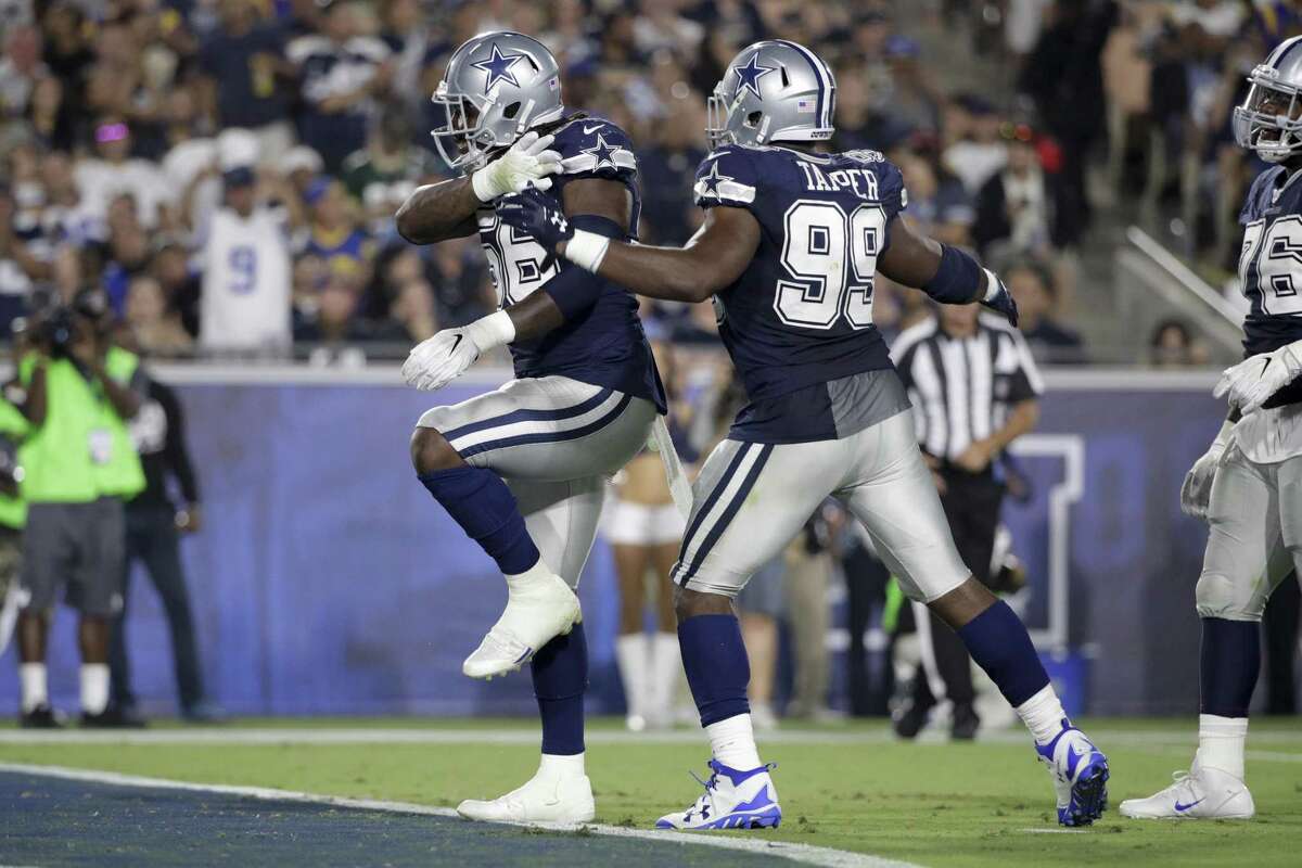 Dallas Cowboys defensive end Lenny Jones (56) celebrates a sack with teammate defensive end Charles Tapper (99) during the second half of a preseason NFL football game against the Los Angeles Rams Saturday, Aug. 12, 2017, in Los Angeles.