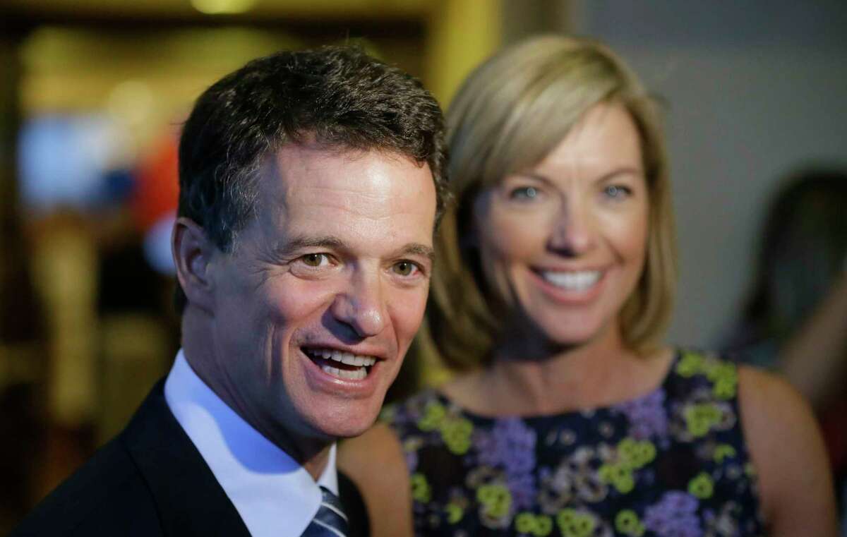 FILE - In this Aug. 5, 2014 file photo, Republican David Trott, a candidate for Michigan's 11th congressional district, stands next to his wife, Kappy, during an interview at his election night party in Troy, Mich. In a statement Monday, Sept. 11, 2017, Trott, R-Mich., says he will not seek re-election. (AP Photo/Carlos Osorio, File)