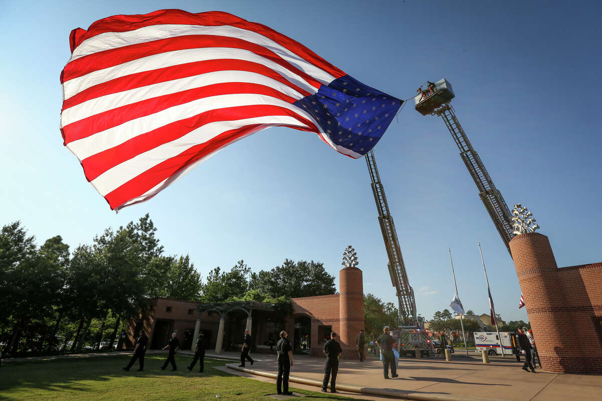 The U.S. flag waves from between two fire engines from The Woodlands Fire Department during the First Responders Day ceremony on Monday at Town Green Park.