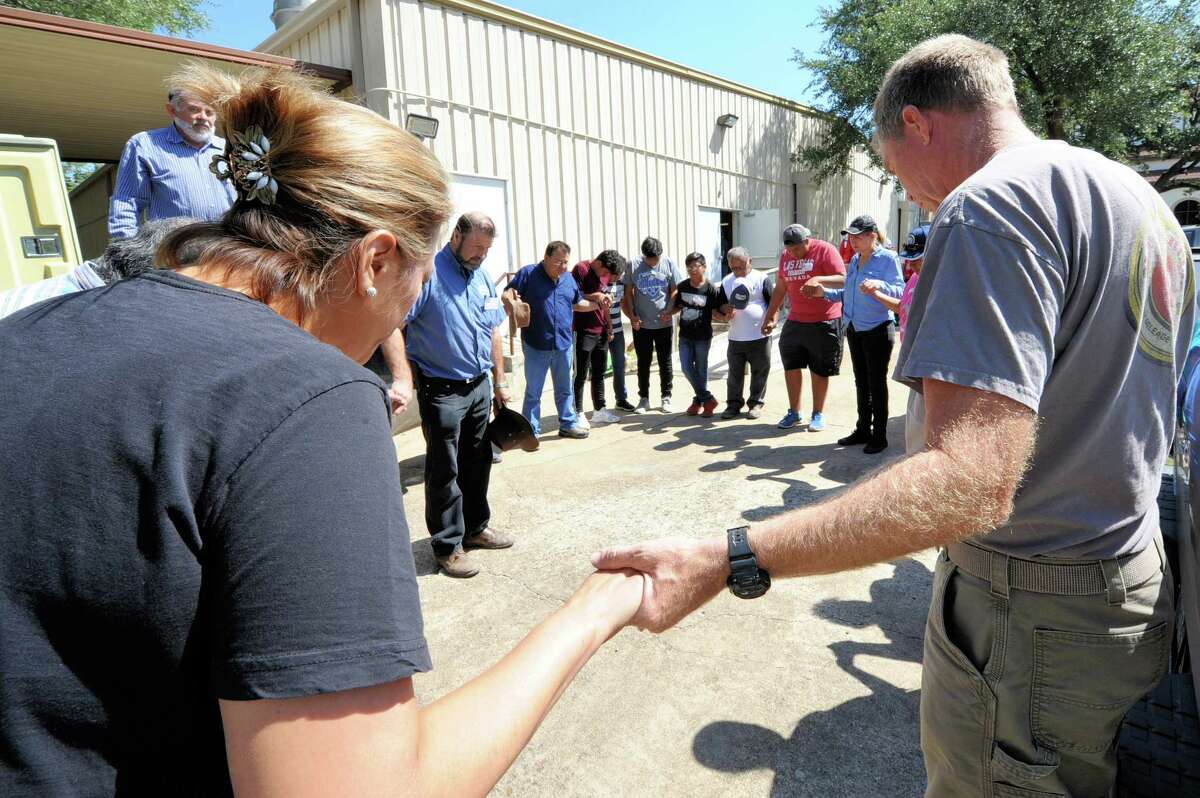 At Our Lady of Guadalupe Church in Rosenberg, TX, volunteers form a prayer circle before distributing hot meals to flood victims on September 7, 2017.