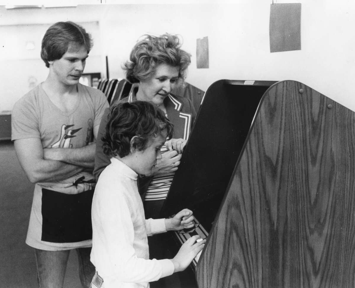 Rick Enszer, left, and Jill and Jon Tessin at The Corridor arcade. June 1982  