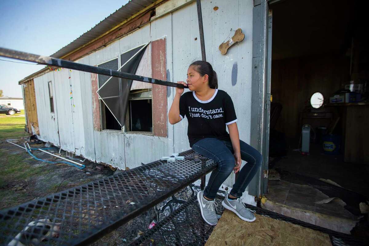 Jazmyn Oviedo, 10, sits on what was the front entrance to her family's home in Tivoli, TX, while her father salvages lumber to help fix another roof in the community, Tuesday, Sept. 12, 2017. Jazmyn and her family were not home when Hurricane Harvey hit, but when they returned home, they found their trailer and two additional relatives' trailers destroyed by the storm. Tivoli, an unincorporated town located between Port Lavaca and Rockport, was hit hard by Hurricane Harvey.