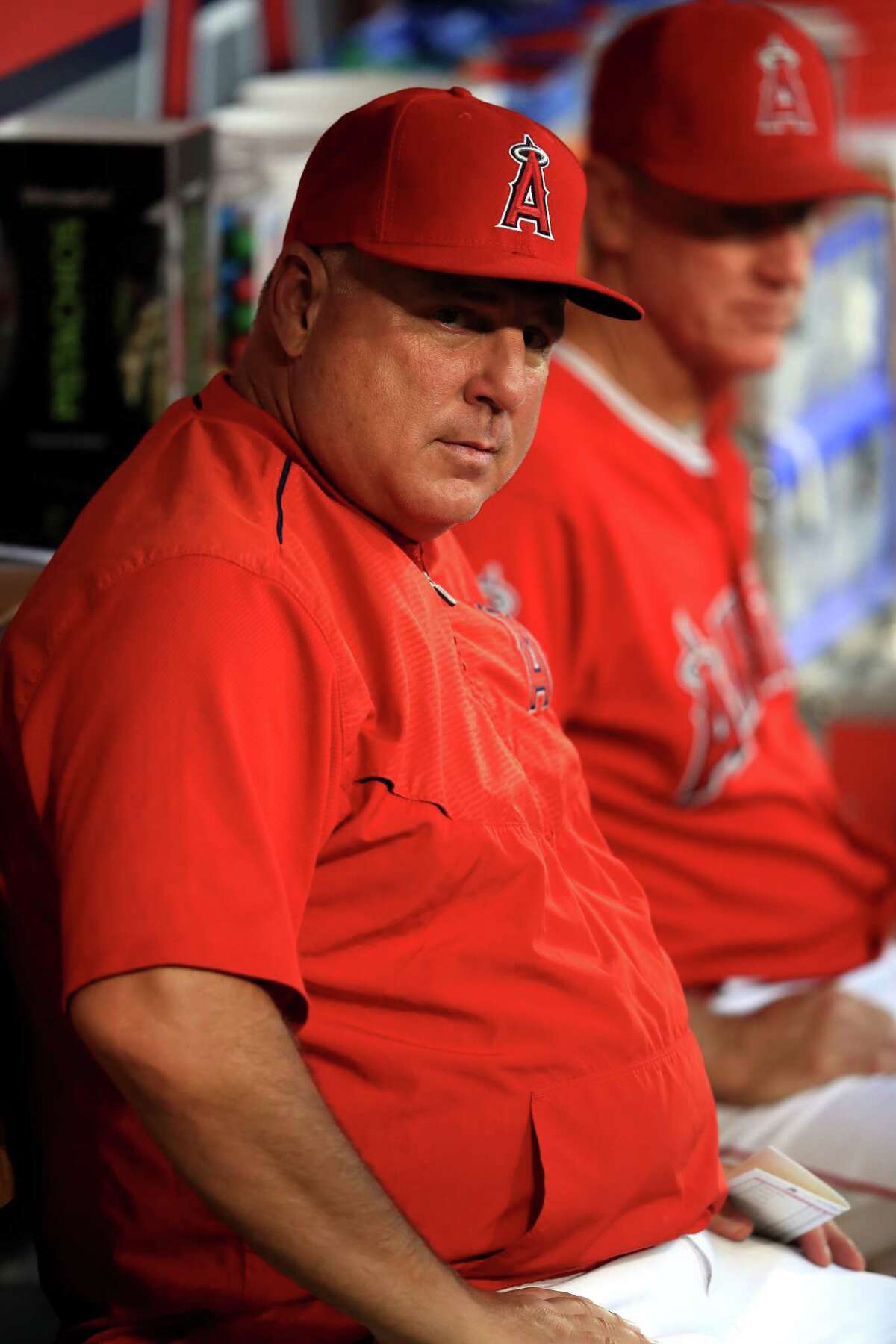 ANAHEIM, CA - SEPTEMBER 12: Manager Mike Scioscia of the Los Angeles Angels of Anaheim looks on from the dugout during the first inning of a game against the Houston Astros at Angel Stadium of Anaheim on September 12, 2017 in Anaheim, California.