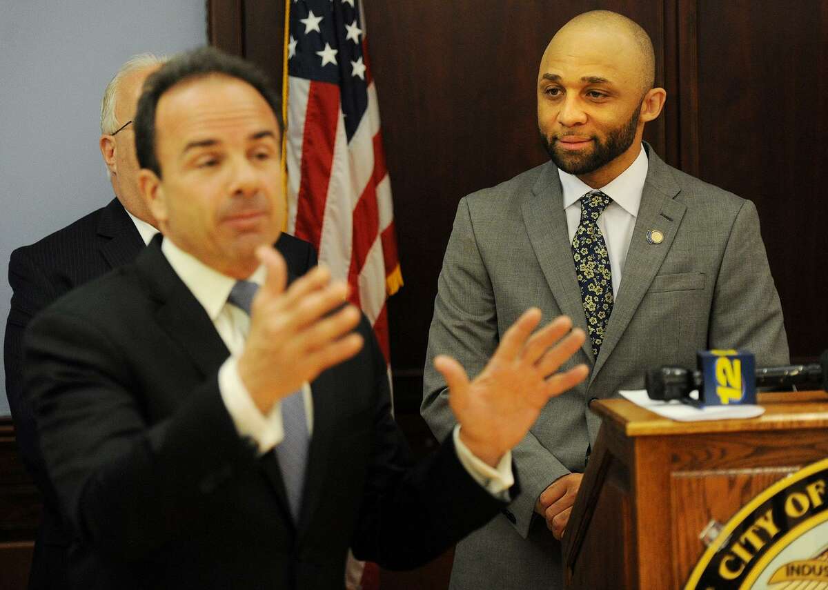 Louis Reed, right, former program manager of the Mayor's Initiative for Reentry Affairs, looks on as Bridgeport Mayor Joe Ganim speaks in May on a memorandum granting individuals with prior convictions scholarships to Housatonic Community College's advanced manufacturing certificate program. Reed, who was granted a continuance in his case for an alleged fraudulent check scheme on Wednesday, September 13, 2017, is facing charges in Trumbull.
