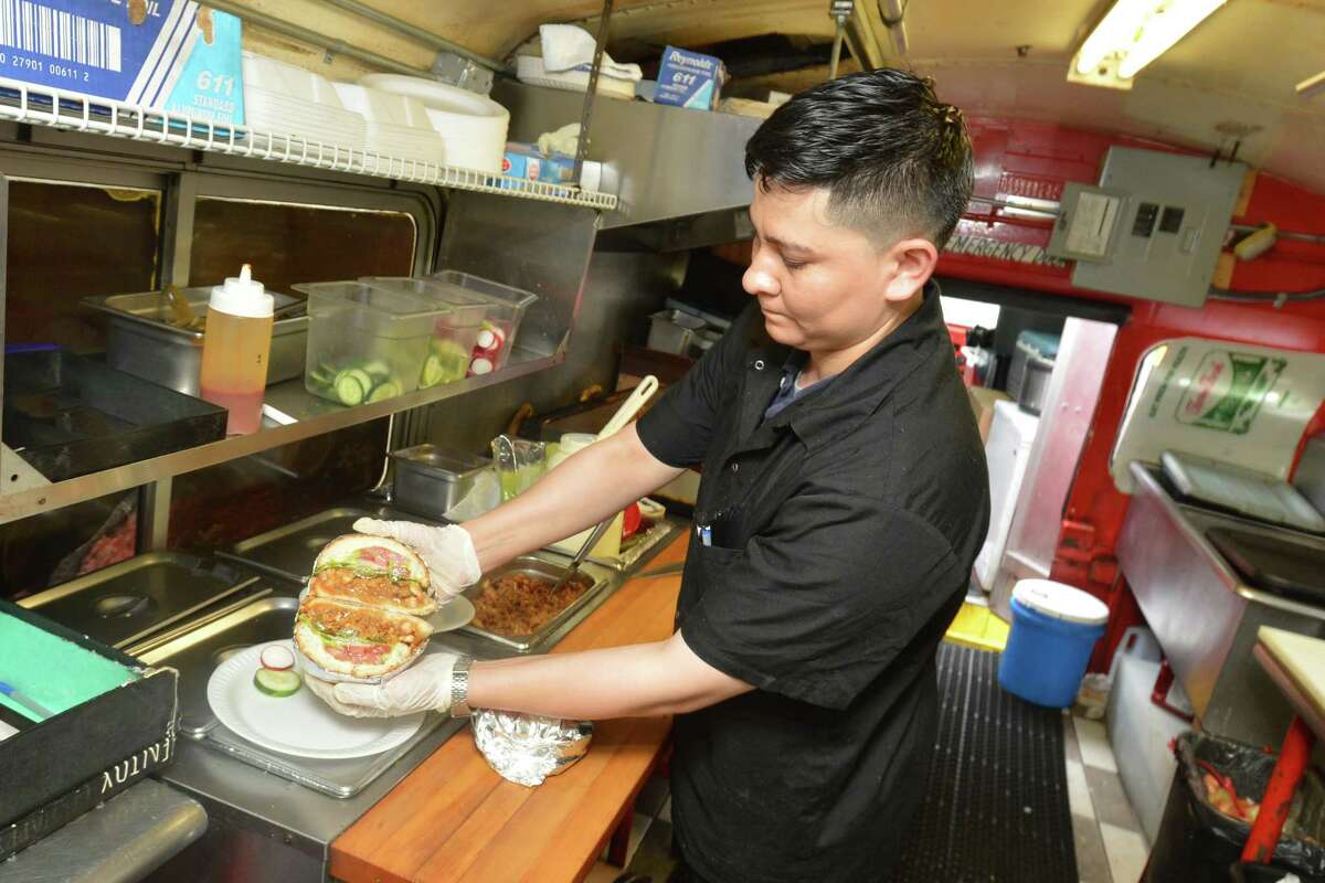 Chef Gino España makes a grilled pork Torta for a customer during lunch hour at Tacos El Azteca Don Juan food truck along Main St. on Wednesday September 13, 2017 in Norwalk Conn.