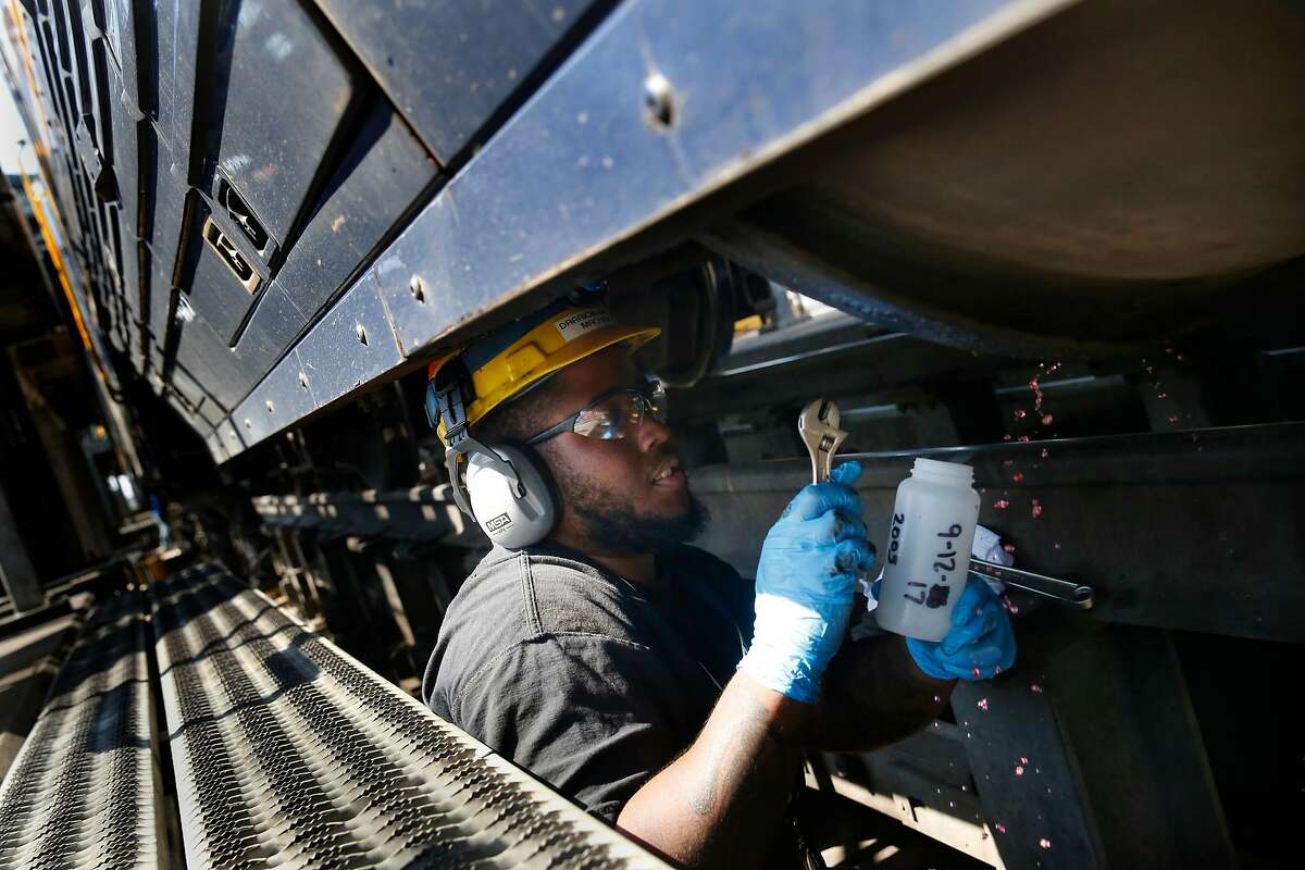 Darrion Brown, Amtrak machinist, takes a sample of renewable diesel from the fuel tank on a Capital Corridor locomotive for testing for contaminants, degredation and to make sure it meets quality standards at the Amtrak Maintenance Facility on Tuesday, September 12, 2017 in Oakland, Calif.
