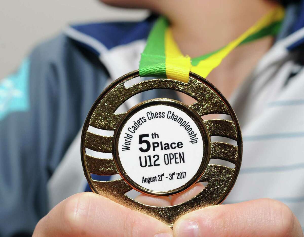 Max Lu, 11, of Greenwich, holds the medal he won during the recent World Cadets Chess Championship in Brazil as he poses at the Greenwich Time, Conn., Tuesday, Sept. 12, 2017. Lu placed 5th in his age division at the championship.