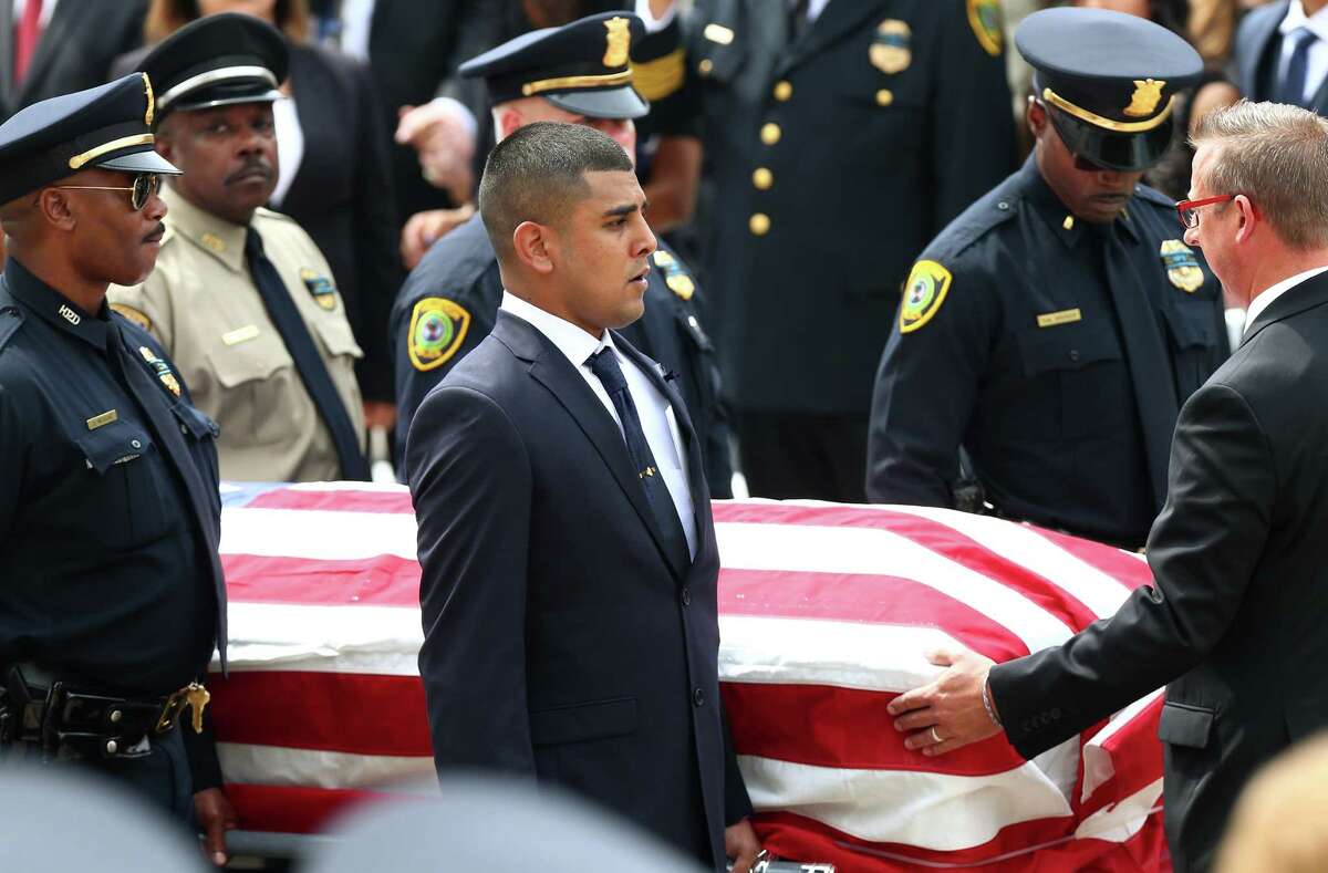 Maverick Perez, along with the other pallbearers, carries his father's coffin outside Co-Cathedral of the Sacred Heart church Wednesday, Sept. 13, 2017, in Houston. Perez's father, Houston Police Sgt. Steve Perez, 60, died in the line of duty while reporting for work during Hurricane Harvey.