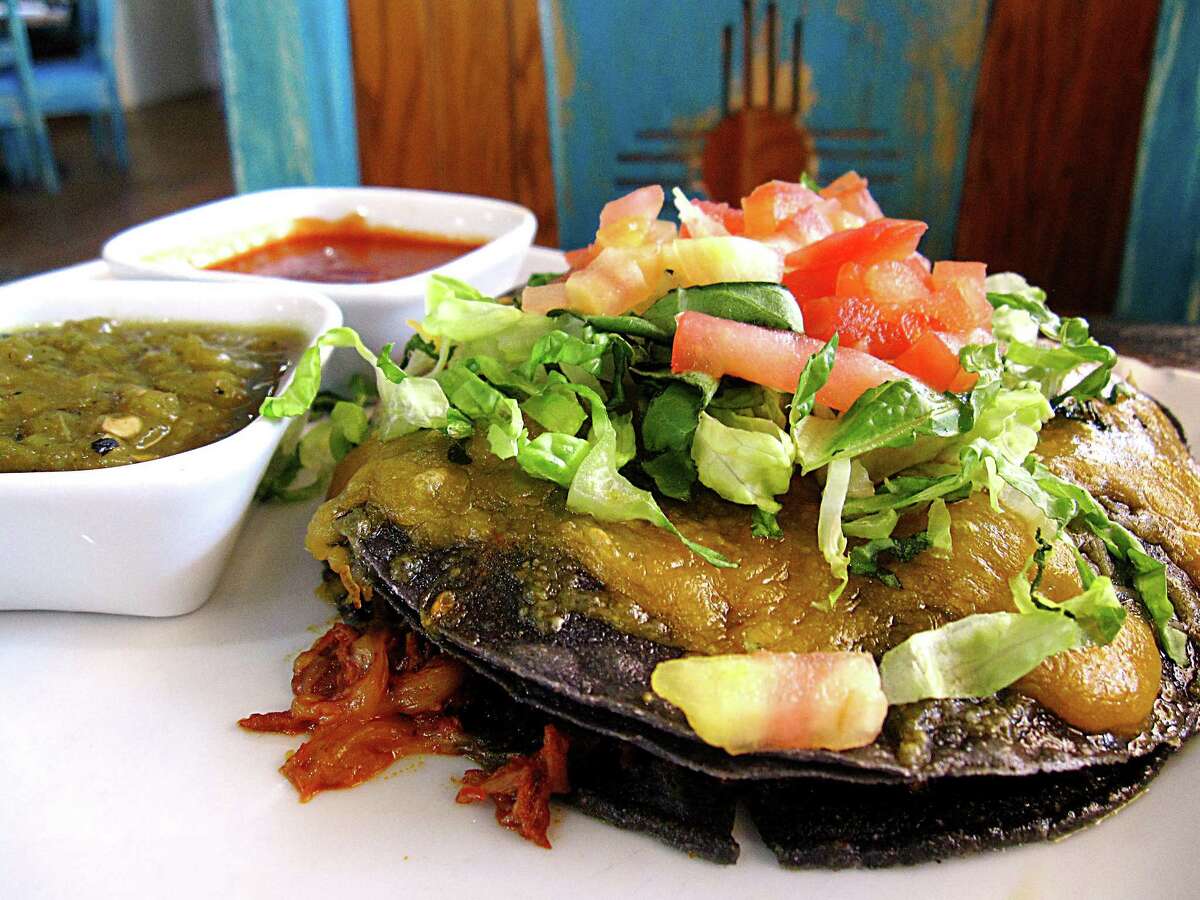 Blue corn stacked enchiladas with pork adobado, lettuce, tomatoes and cheese with a “Christmas” set of green and red chile sauces from Santa Fe Trail Mexican Cuisine on San Pedro Avenue.