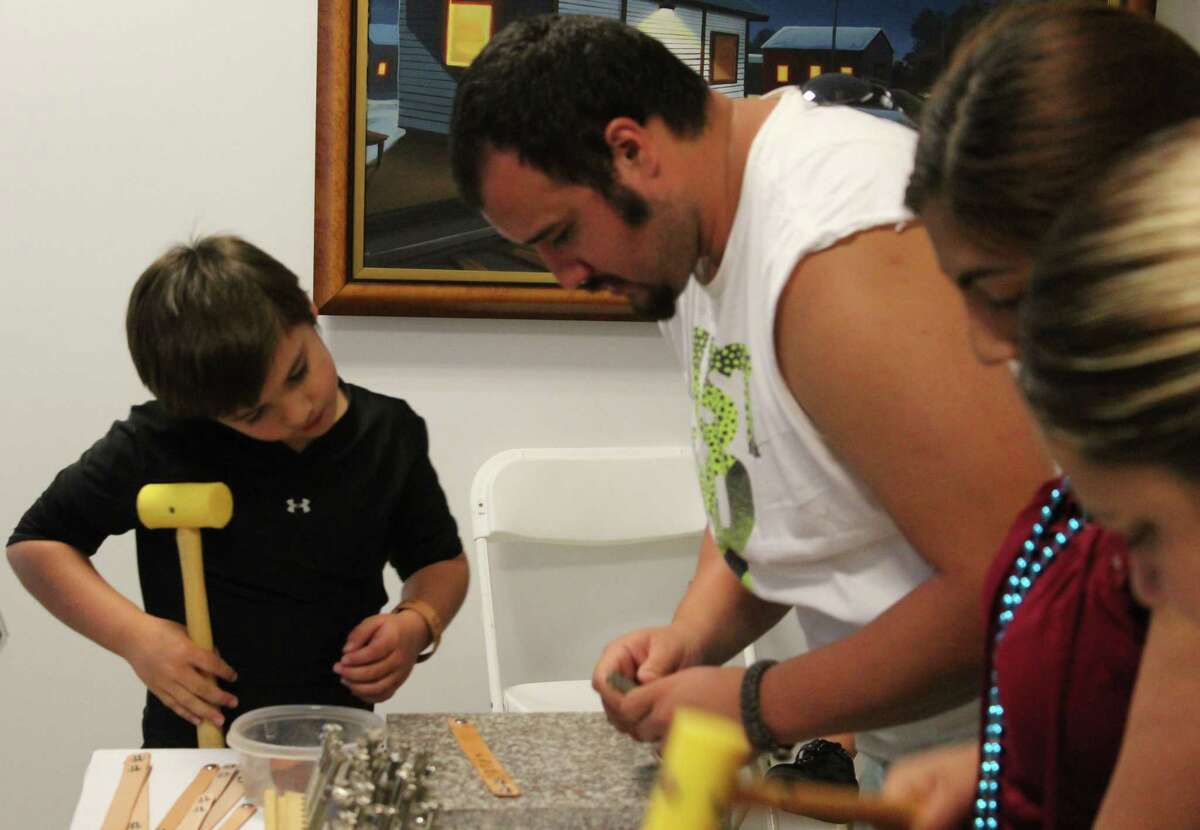 Daniel PeÃ©±a III (left) makes a special, custom bracelet with assistance from his father, Daniel PeÃ©±a Jr. (right), at the Back to School Bash.