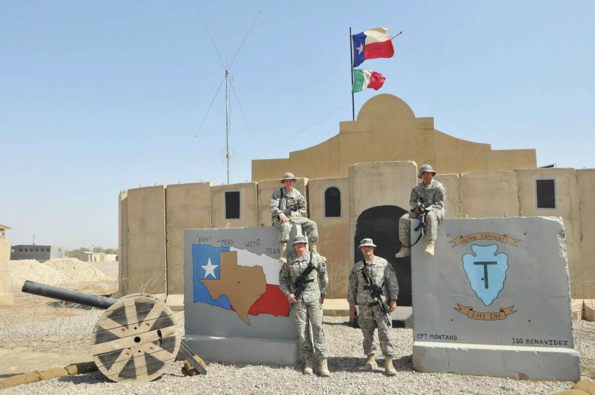 The photo shows four unnamed members of the 141st standing outside the Tactical Operations Center in Camp Liberty near Baghdad. Taken in 2010, the photo shows the building adorned with the iconic Alamo roofline made of painted plywood