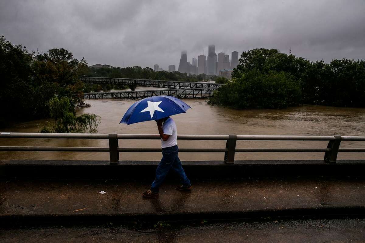 Armando Bustsamante walks along the street over Buffalo Bayou as flood waters from Tropical Storm Harvey flow toward downtown Houston Tuesday, Aug. 29, 2017. More than 17,000 people are seeking refuge in Texas shelters, the American Red Cross said. With rescues continuing, that number seemed certain to grow. (Michael Ciaglo/Houston Chronicle via AP)Purchase your copy here.