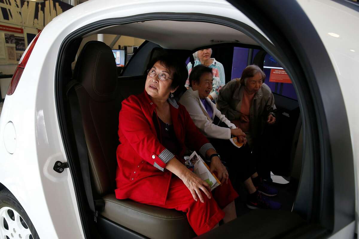 Kate Gong (left) and friends sit inside a Waymo self-driving car displayed at the Computer History Museum in Mountain View, Calif. on Wednesday, July 12, 2017.