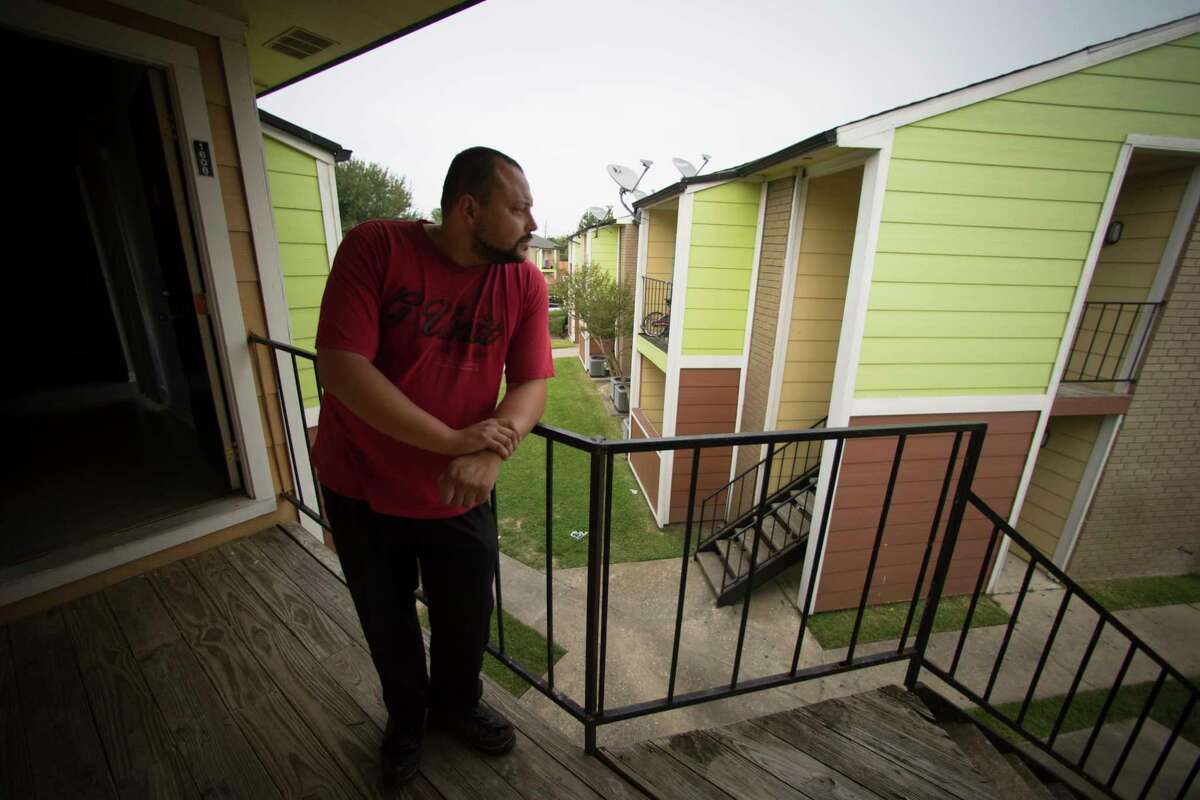 Steven Calhoun, 31, stands on the balcony of his apartment north of Houston, Wednesday, Sept. 13, 2017. Calhoun missed five days at his job packing airplane meals at George Bush Intercontinental Airport, and now is facing an eviction notice, on top of struggling to afford food. He's applied for FEMA aid and disaster unemployment insurance, but that takes weeks to process.