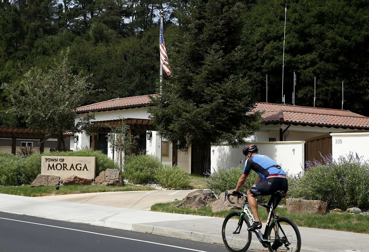 A bicyclist rides past 335 Rheem Boulevard, where the Town Council meets, Wednesday, Sept. 6, 2017, in Moraga, Calif. The town of Moraga declared a fiscal emergency June 28.