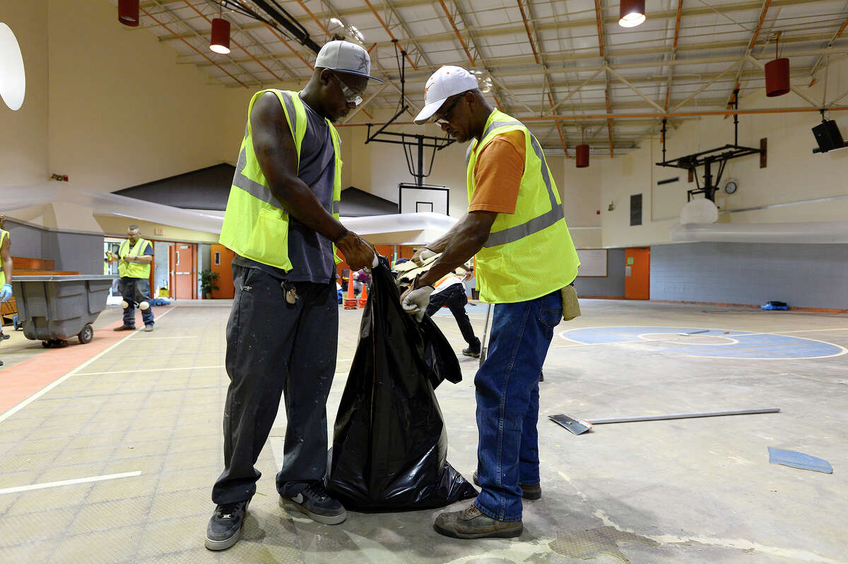 Workers remove the flooring in the gym at Vidor Middle School on Thursday. The school's fifth graders will go to class in a separate wing at Vidor High School, and the sixth graders will go to the junior high. Photo taken Thursday 9/14/17 Ryan Pelham/The Enterprise