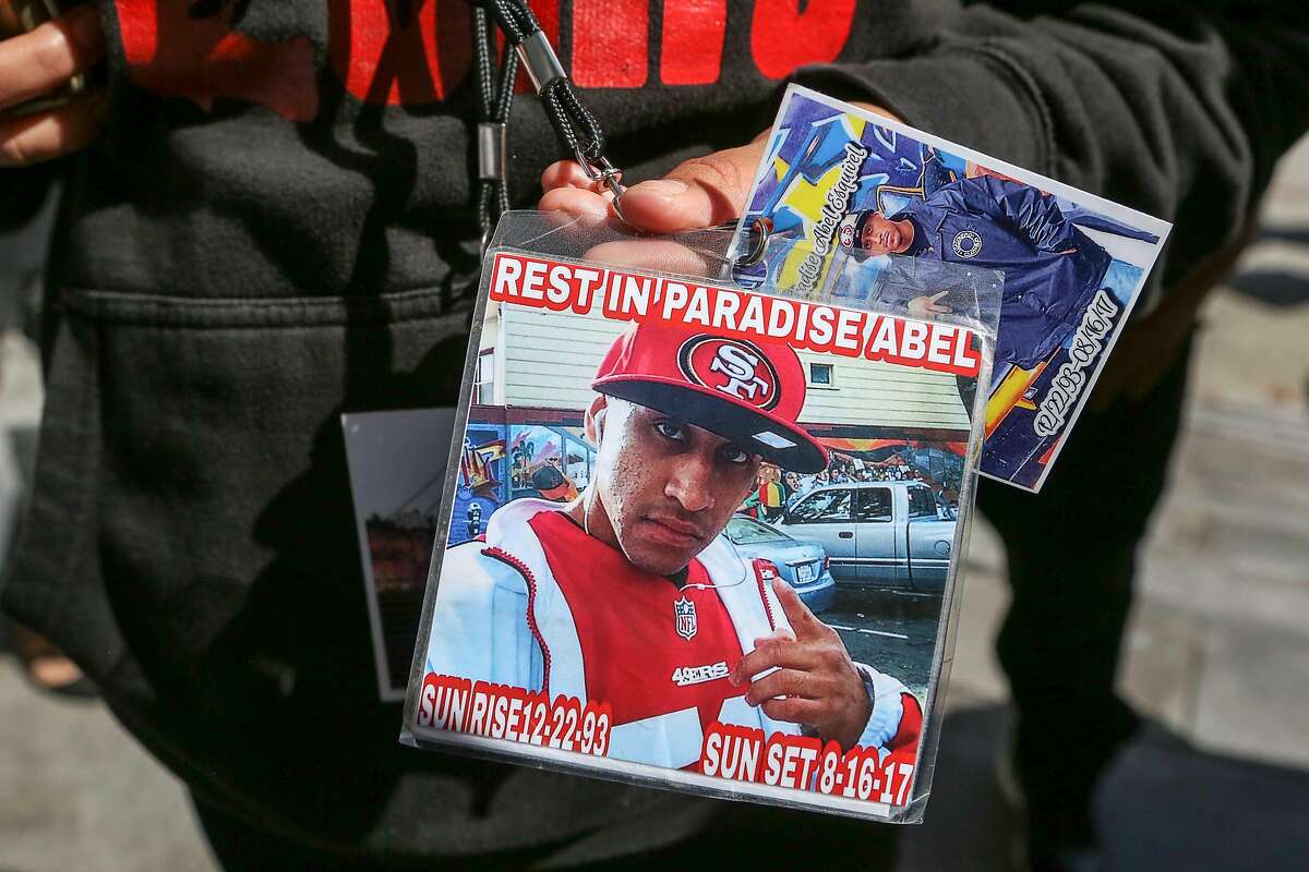 The girlfriend of Abel Enrique Esquivel (who did not wish to be identified) holds up several badges dedicated to Abel that she wears around her neck after the arraignment of the man accused of murdering him on Thursday, September 14, 2017 at the Hall of Justice in San Francisco, Calif.