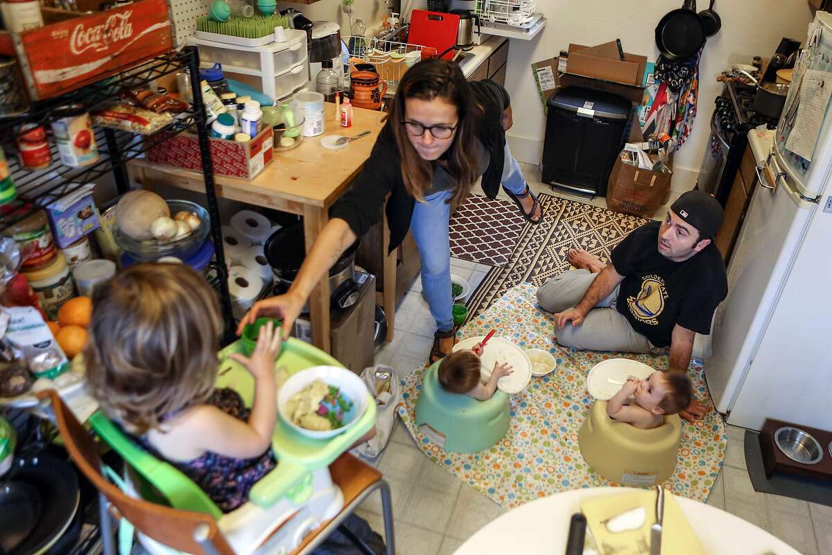 Sarah Montoya and husband Trevor McNeil make due in their cramped kitchen while feeding dinner to their 8 month old twins and two year old daughter on Friday, September 8, 2017 in San Francisco, Calif.