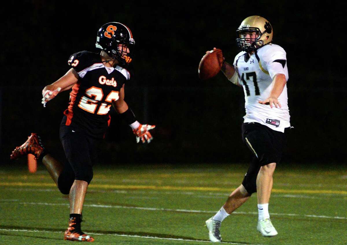 Shelton's Michael Casinelli, left, tries to tackle Daniel Hand QB Phoenix Billings during football action in Shelton, Conn. on Friday Sept. 15, 2017.