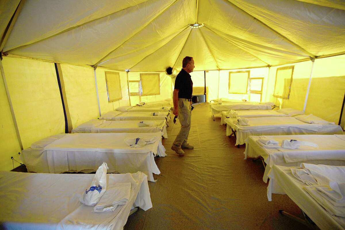 The interior of one of the 12-bed family shelters are seen as the Incident Commander with Emergency Management offers a tour of the tent city shelter that will house displaced residents on the grounds of the Bob A. Bowers Civic Center in Port Arthur. Those sheltering in the Red Cross site at Thomas Jefferson Middle School will be the first to arrive Friday. Next, those who were transported to Dallas, San Antonio, and elsewhere will be repatriated, as well as those who have been evicted from their residences. A second tent city is approved for construction at a different location should the need for shelter grow beyond the capacity of this unit. Photo taken Friday, September 15, 2017 Kim Brent/The Enterprise