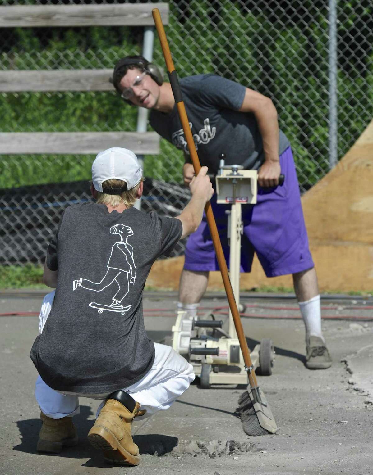 Russell Parker, of Sherman, gets help lining up a saw from Tristan Cornelis, of New Milford, while working to bring the New Milford Skate Park up to code. Thursday, August 3, 2017, in New Milford, Conn.