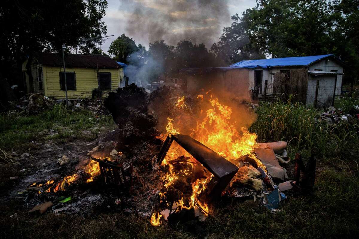 A woman burns the flooded contents of her living room behind her home on Jackson Quarters Lane that was flooded by two and a half feet of water after Hurricane Harvey Tuesday, Sept. 12, 2017 outside Wharton. ( Michael Ciaglo / Houston Chronicle)