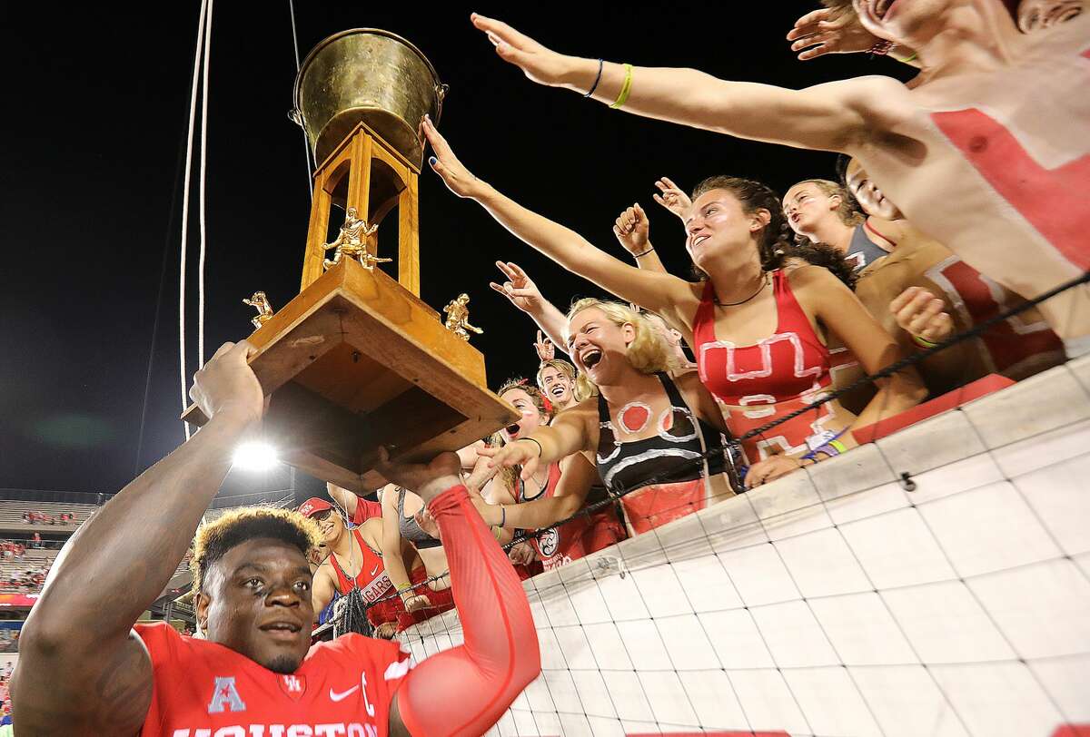 Houston Cougars linebacker Matthew Adams (9) holds the Bayou Bucket over his head for the fans touch after the team's 38-3 win over Rice at TDECU Stadium on Saturday, Sept. 16, 2017, in Houston. Houston won the game 38-3 over Rice. ( Elizabeth Conley / Houston Chronicle )