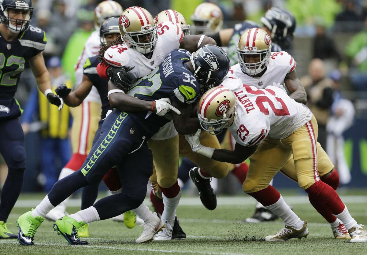 Seattle Seahawks running back Chris Carson (32) rushes against San Francisco 49ers free safety Jaquiski Tartt (29) as he is tackled by 49ers' Ray-Ray Armstrong (54) in the second half of an NFL football game, Sunday, Sept. 17, 2017, in Seattle. (AP Photo/John Froschauer)