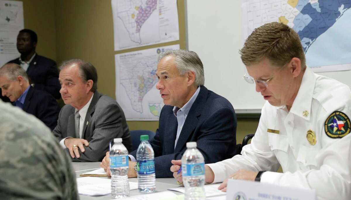 Texas Gov. Greg Abbott, center, and Commissioner John Sharp, seated second from left, receive a briefing on Hurricane Harvey recovery efforts at the new FEMA Joint Field Office, Thursday, Sept. 14, 2017, in Austin, Texas. (AP Photo/Eric Gay)