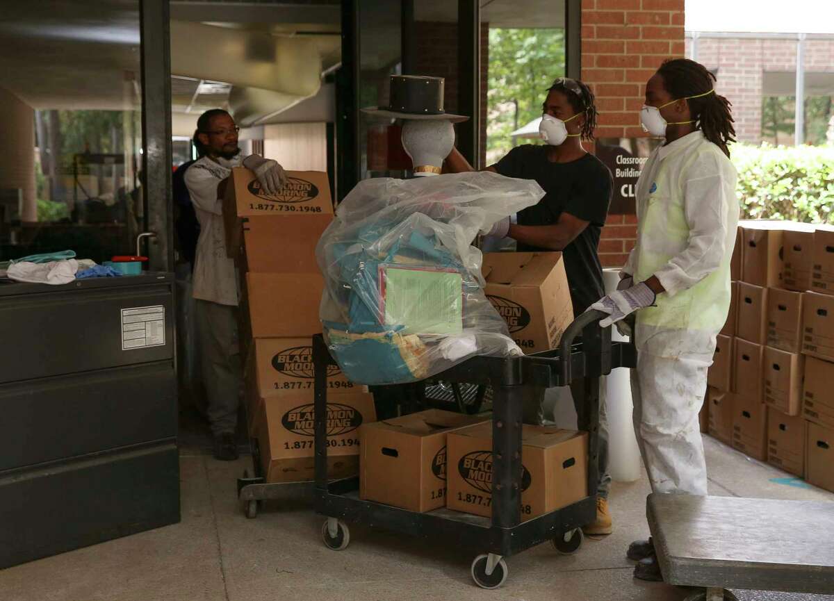 Workers remove salvaged classroom materials from Lone Star College-Kingwood's Classroom Building B during cleaning recently. Hurricane Harvey flooding has forced the college to move 73 percent of campus courses online.