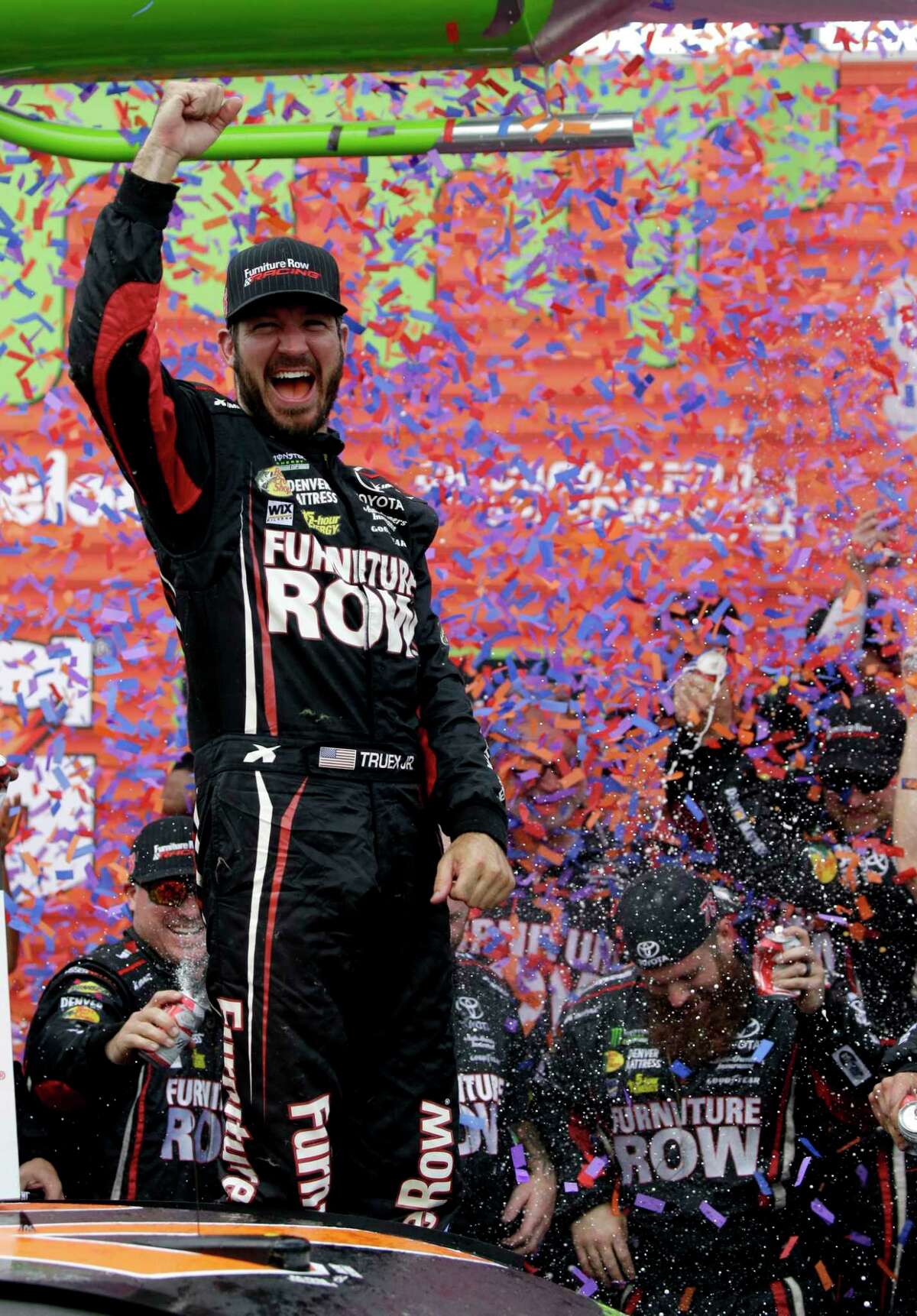 Martin Truex Jr. celebrates with his crew in Victory Lane after winning a NASCAR Cup Monster Energy Series auto race at Chicagoland Speedway in Joliet, Ill., Sunday, Sept. 17, 2017. (AP Photo/Nam Y. Huh)