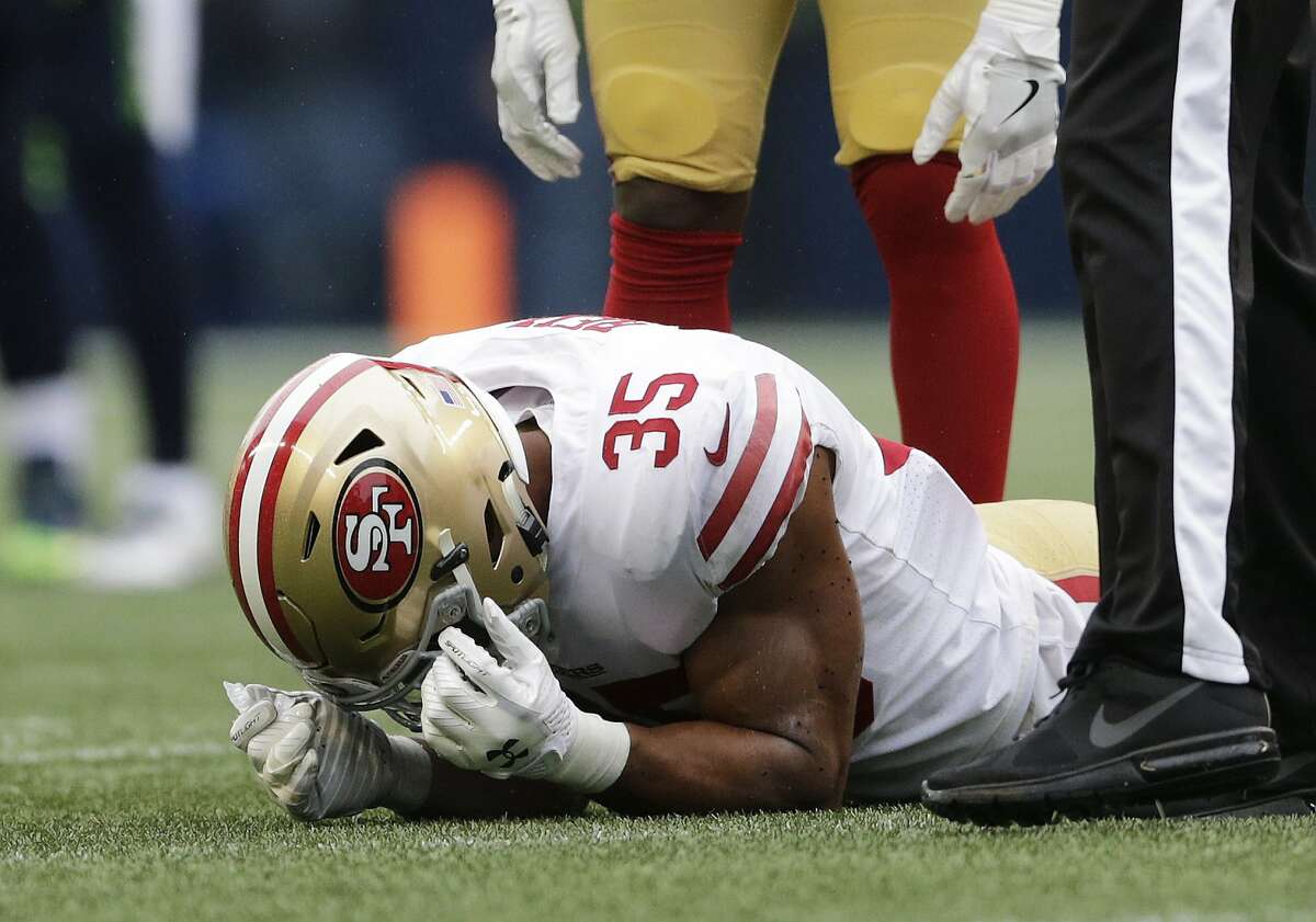San Francisco 49ers strong safety Eric Reid rests on the turf with an injury in the second half of an NFL football game against the Seattle Seahawks, Sunday, Sept. 17, 2017, in Seattle. Reid left the game game on the play. (AP Photo/John Froschauer)