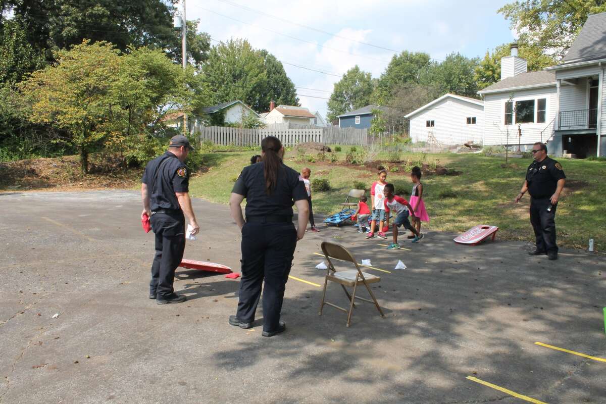 Members of the Edwardsville Fire Department toss bean bags with children on Saturday at Anchored in Truth Ministries' Love Fest. The church, located off Garfield Avenue in Edwardsville, hosted the event which featured games and inflatables for children, live music, food and more.