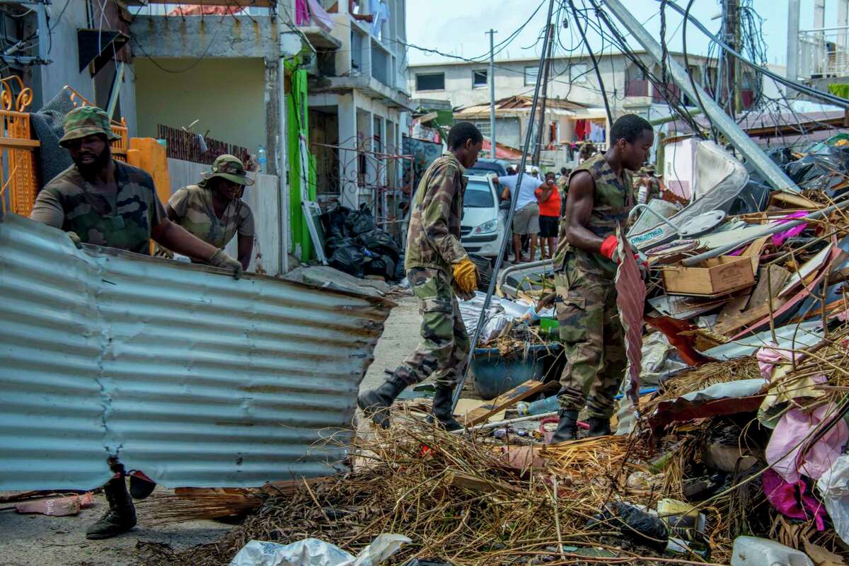 Members of the Guadeloupe Adapted Military Service Regiment clean up debris left by Hurricane Irma on the Caribbean island of St. Martin in advance of Hurricane Maria, which is on a path similar to Irma.﻿