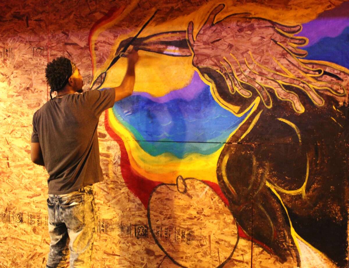 A St. Louis man paints a mural following the recent protest destruction on Delmar Blvd. 