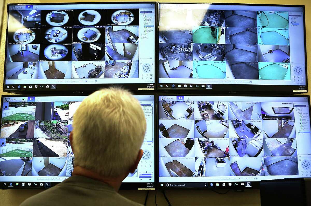 An employee at Compassionate Cultivation, monitors video cameras in the security room at the company that is expected to soon get a license to grow medical cannabis in South Austin.