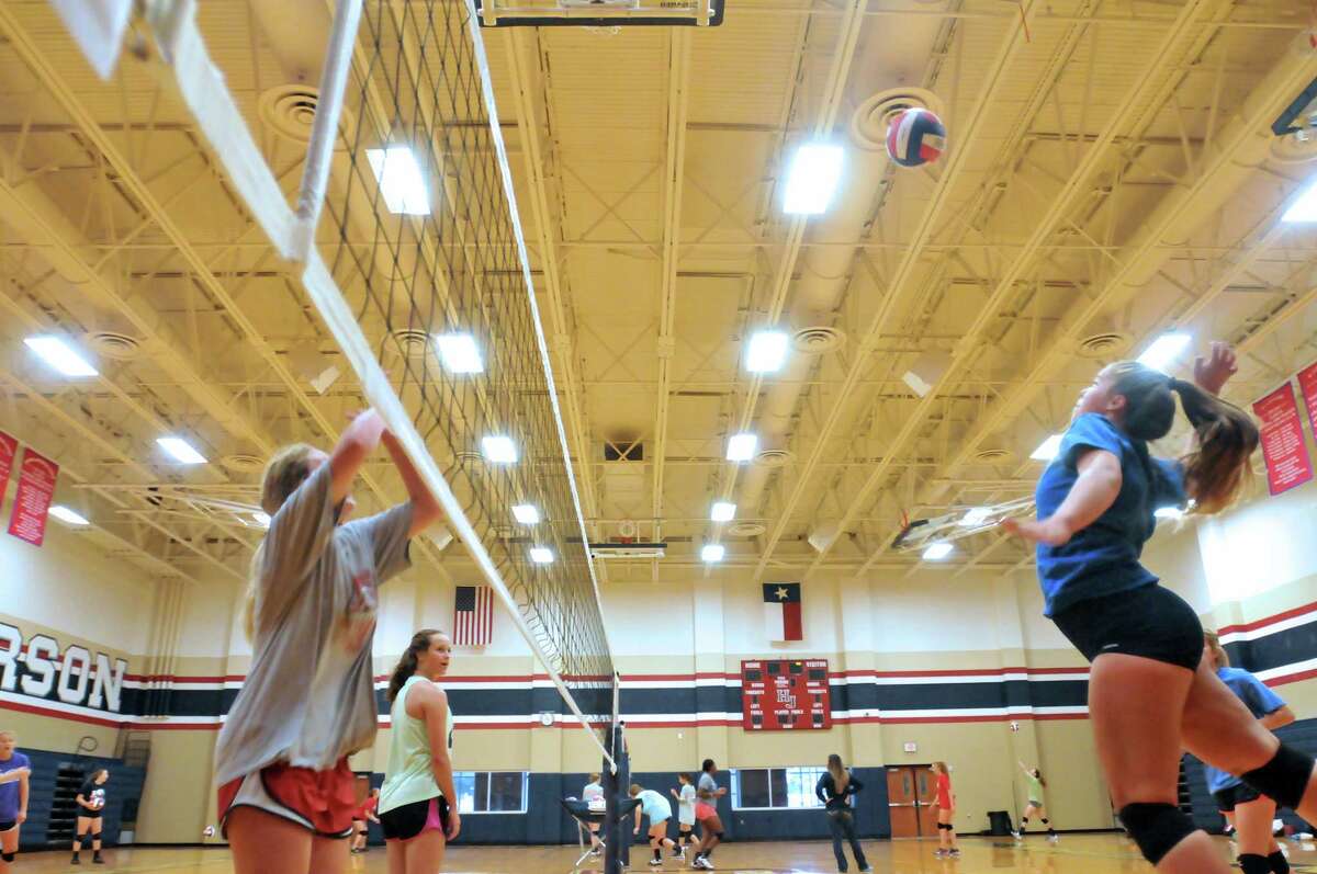 Hardin-Jefferson's Kassidy Shackleford, right, jumps to spike the ball toward teammate Abby Swope, left, during practice Monday at the school's competition gym in Sour Lake. (Mike Tobias/The Enterprise)