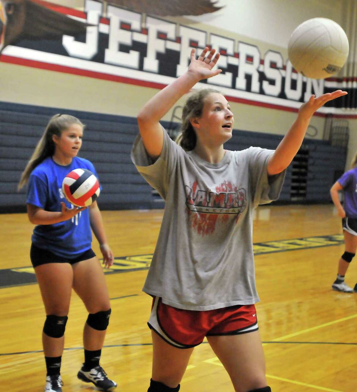 Hardin-Jefferson's Abby Swope, right, prepares to serve the ball while teammate Kassidy Shackleford, left, waits her turn during practice Monday at the school's competition gym in Sour Lake. (Mike Tobias/The Enterprise)