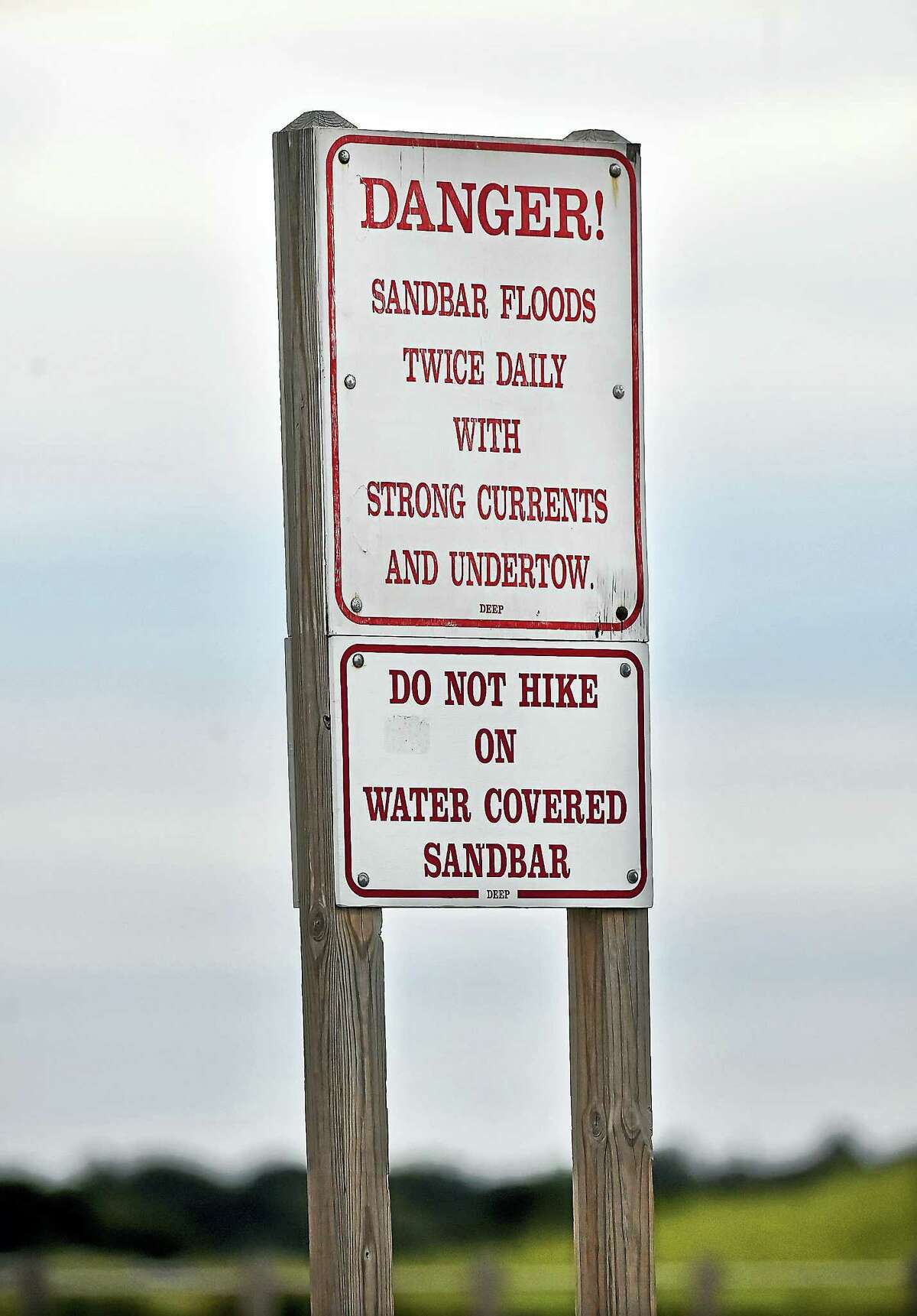 A sign warns beach-goers of strong curtrents and undertow when the sandbar floods at Silver Sands State Park, a public recreation area located on Long Island Sound in Milford, Tuesday, July 25, 2017. (Catherine Avalone – Hearst Connecticut Media)