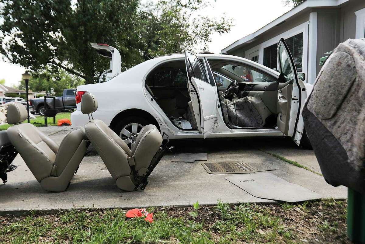 Christina Rodriguez dries out her car in her driveway after it took in water from Tropical Storm Harvey on Friday, Sept. 1, 2017, in Houston. ( Elizabeth Conley / Houston Chronicle )