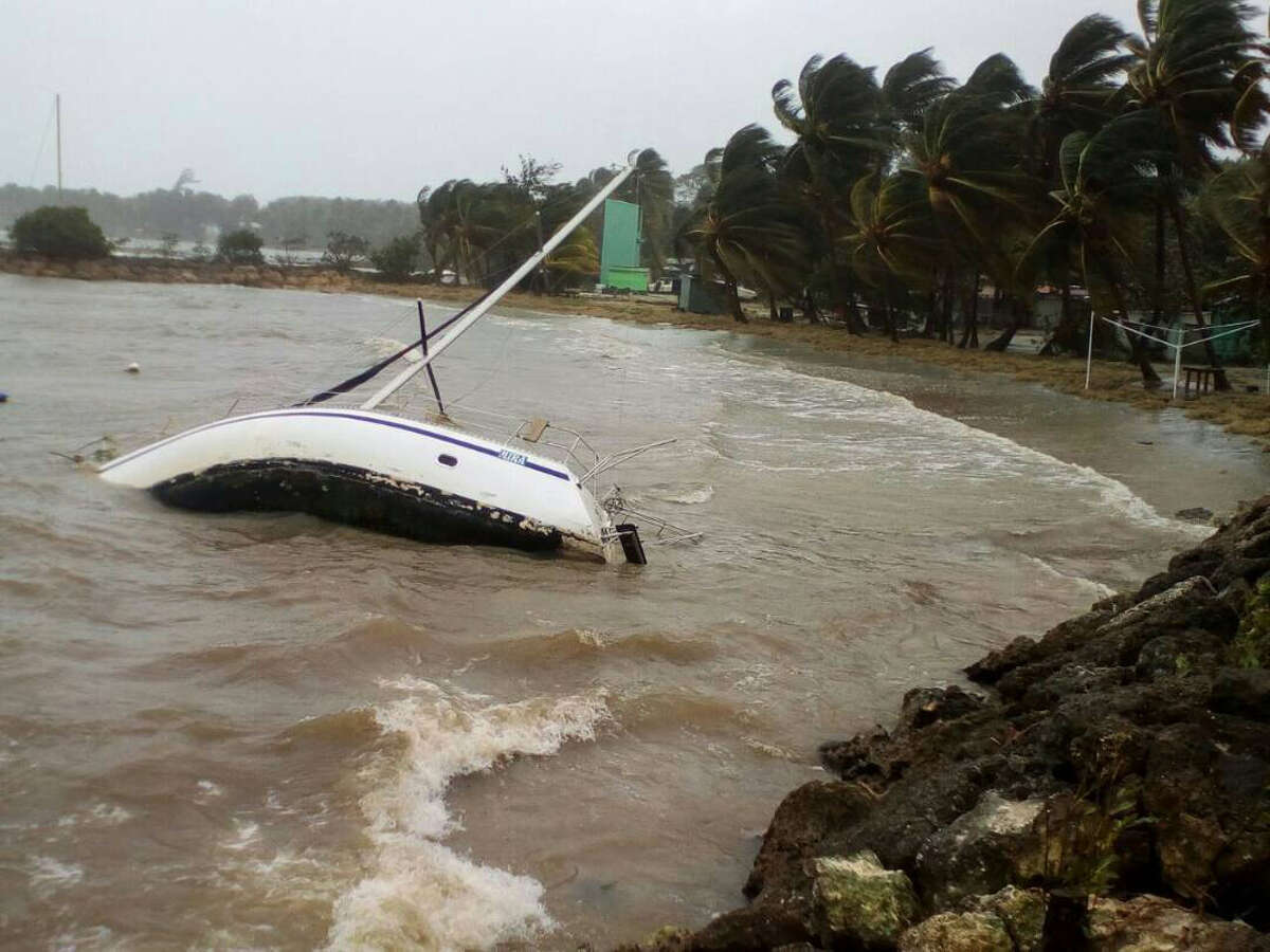 A boat lays on its side off the shore of Sainte-Anne on the French Caribbean island of Guadeloupe, early Tuesday, Sept. 19, 2017, after the passing of Hurricane Maria. (AP Photo/Dominique Chomereau-Lamotte)