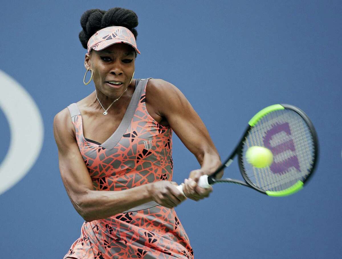 Venus Williams returns a shot from Viktoria Kuzmova during the first round of the U.S. Open tennis tournament Monday. Williams won in three sets.